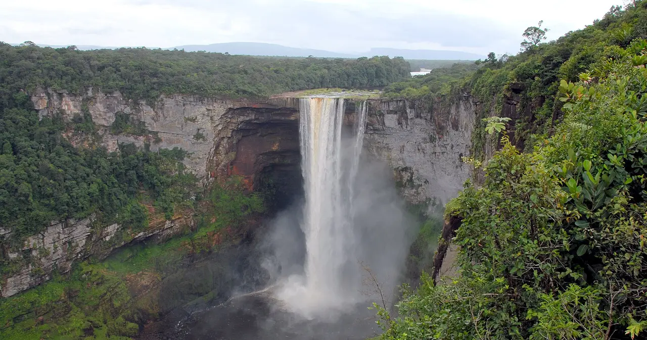 Kaieteur Falls framed by forest, with spray rising from the base of the drop